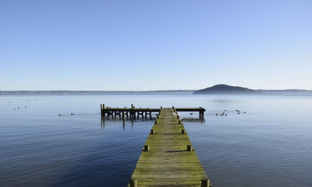 Un ponton ouvert sur l’eau et un horizon de collines